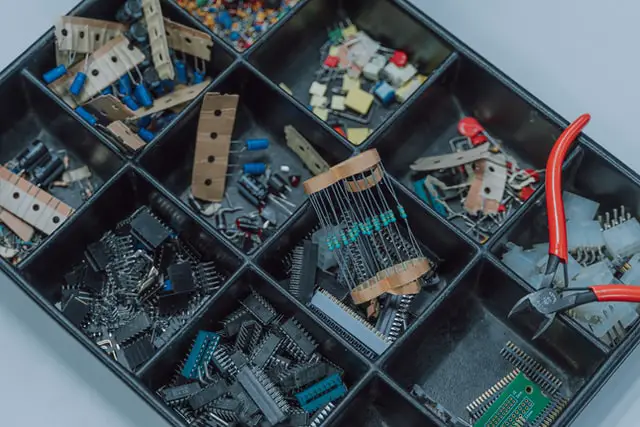 Resistors, capacitors, and inductors sorted in a bin.