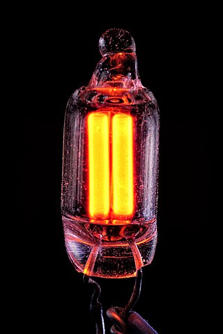A neon lamp fluorescing due to cathode rays (electrons).