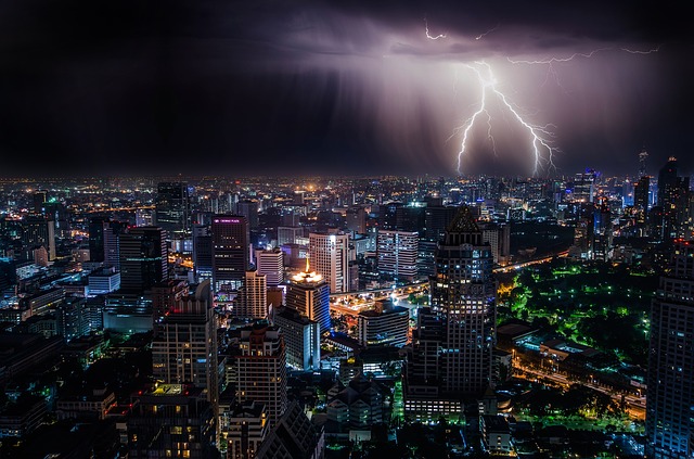 Lightning strikes above a city at night.